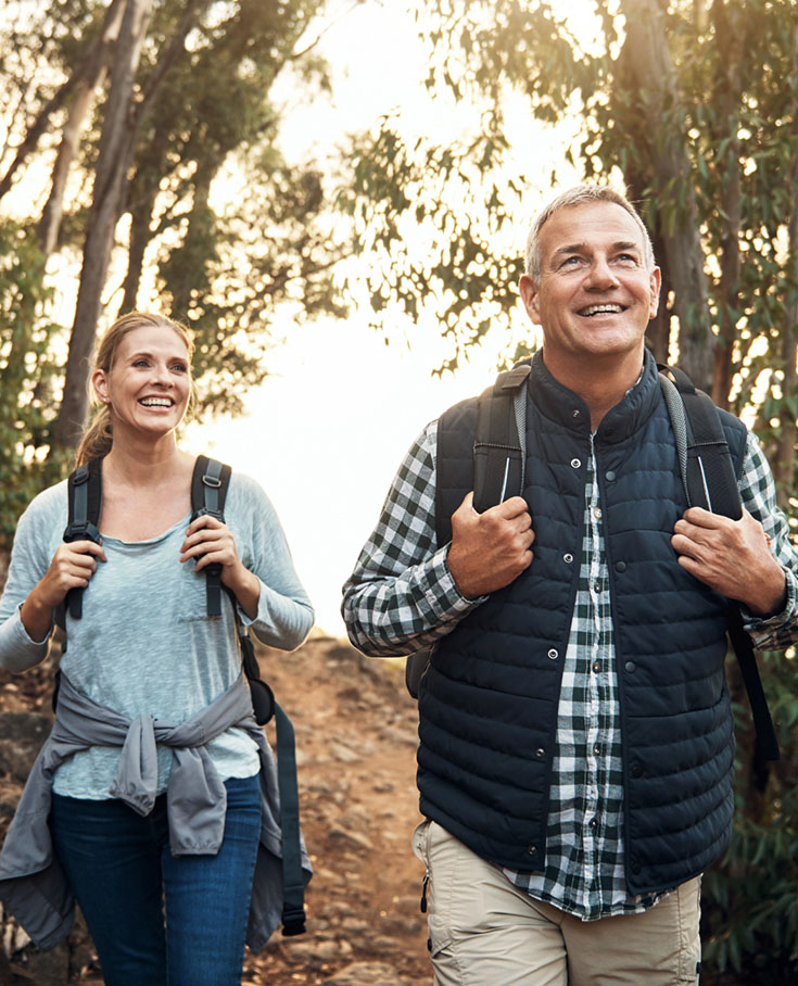 older couple on a hike and smiling for some reason