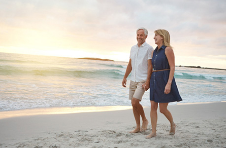 older couple walking on the beach