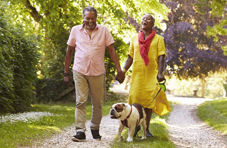 older couple walking with dog
