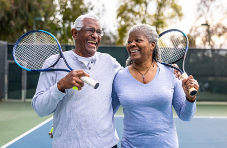 couple holding tennis rackets