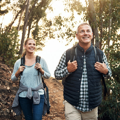 older couple on a hike and smiling for some reason