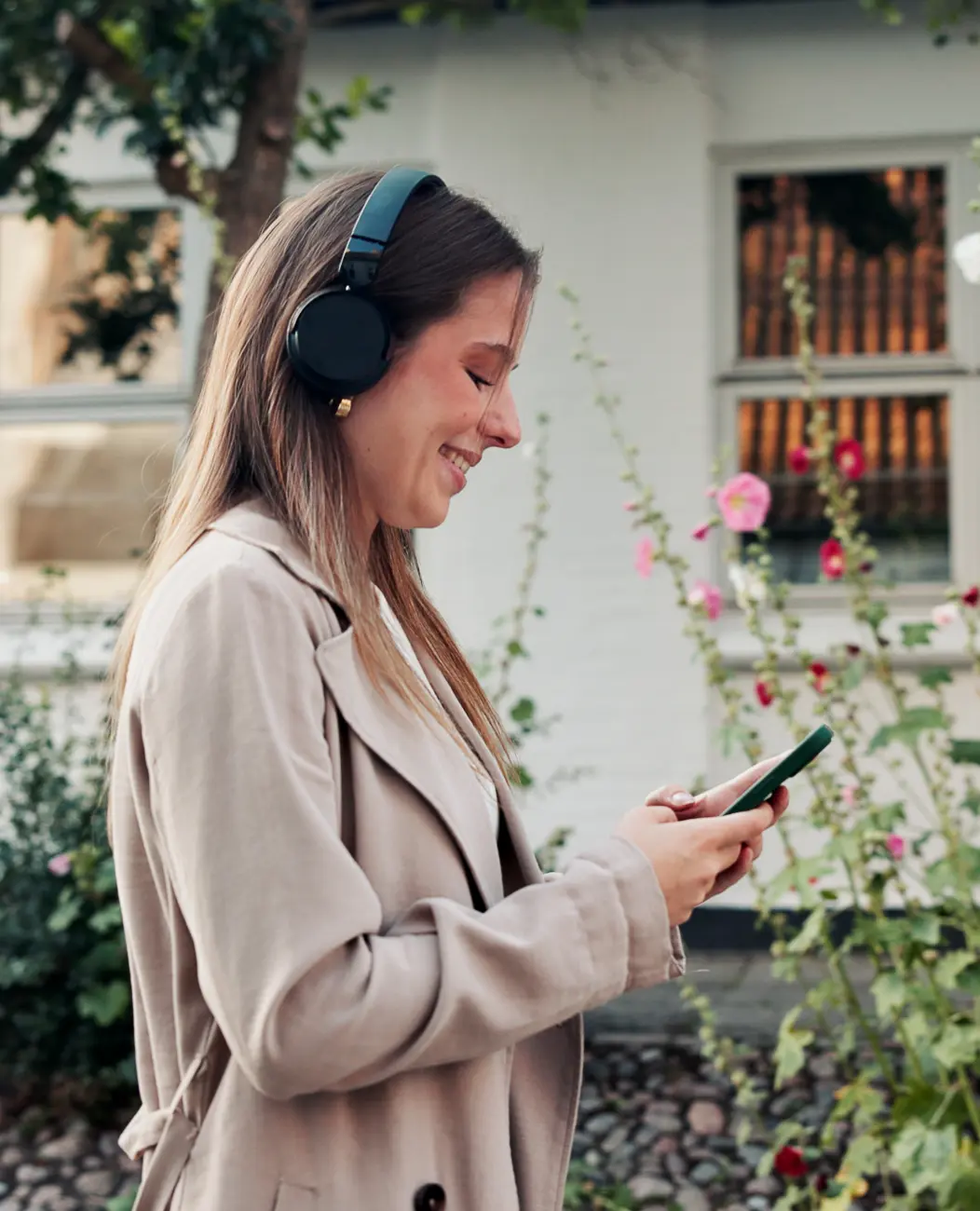 Woman in garden with headphones listening to a podcast